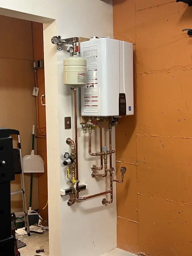 Plumbing technician inspecting water heater connections in Hollidaysburg